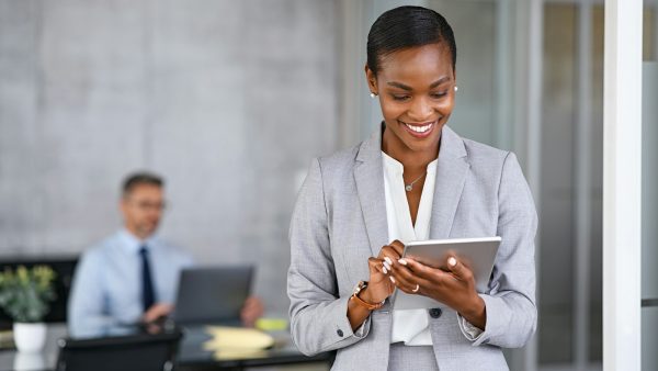 Black business woman using digital tablet in meeting room