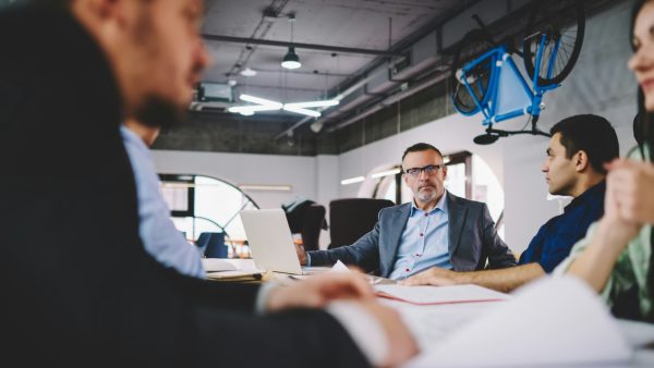 Experienced owners in formal wear talking about competition and entrepreneurship in entreprise firm