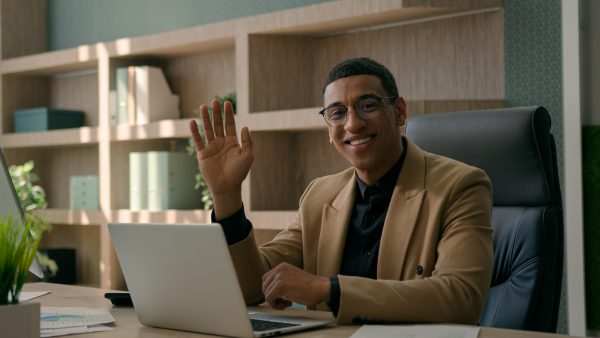 Happy African American man working with laptop computer at office remote job business commerce