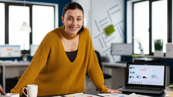 Happy manager standing in office of start up company