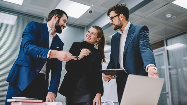 Smiling female manager working together with colleagues in modern office